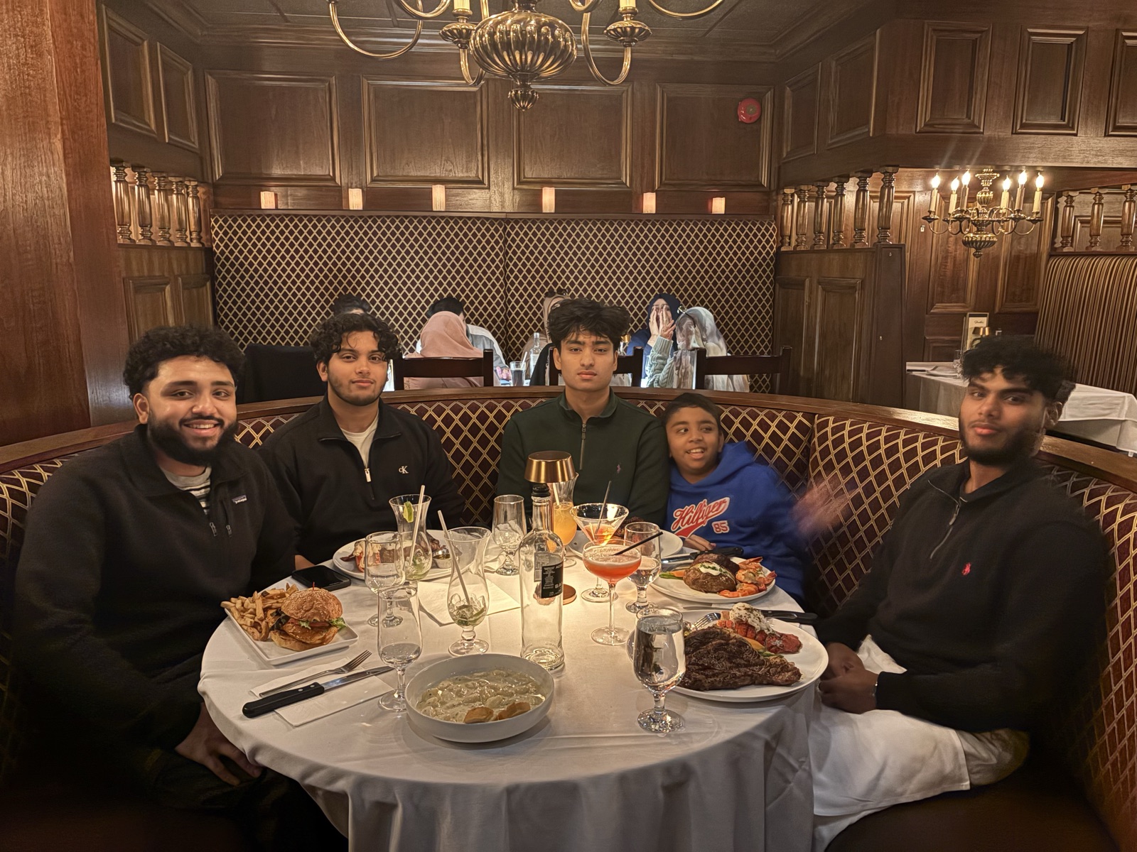 Friends sharing a meal in a wood-panelled restaurant