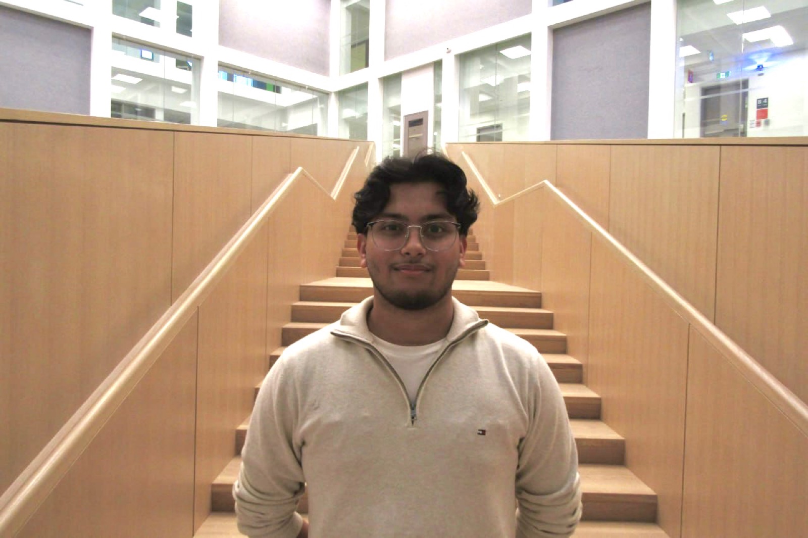 Fahmid standing in front of a wooden staircase