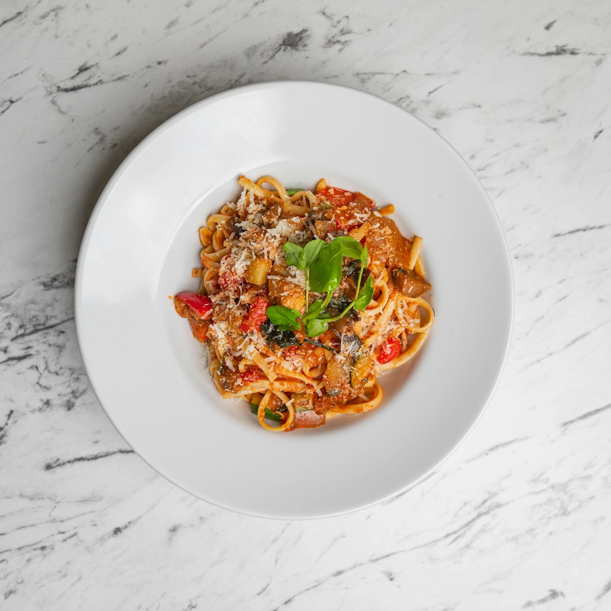 A finished pasta dish with tomato sauce and cheese